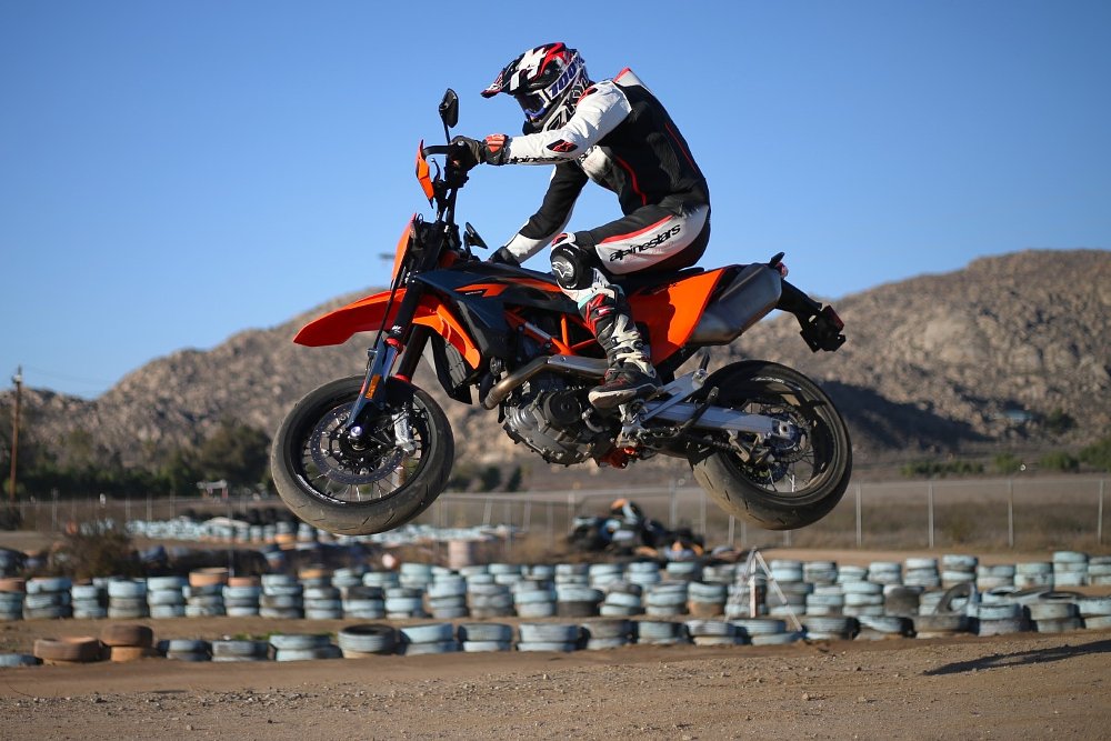 Dylan on the KTM 690 SMC R flying through the air on the dirt section of the track