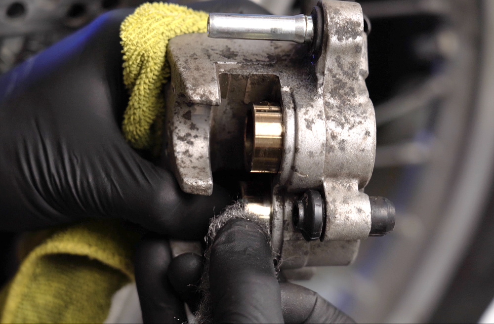Cleaning motorcycle brake caliper pistons